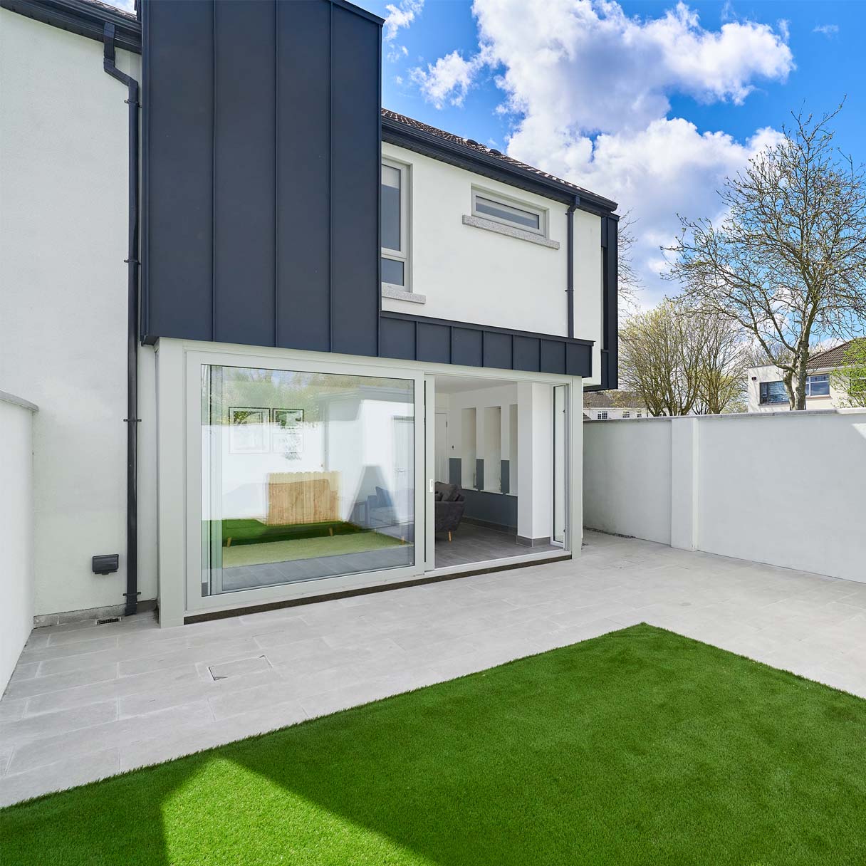 Contemporary garden, glazed doors and dark metal cladding at Garrett’s Sycamore project